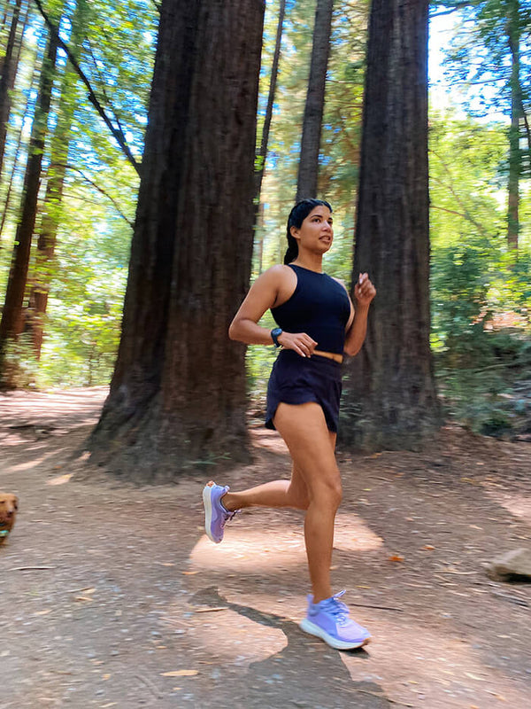 Woman running in the forest wearing Hilma Running Shoes in Purple 